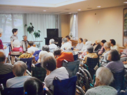 音楽会の様子（アコーディオン演奏を聴く利用者）